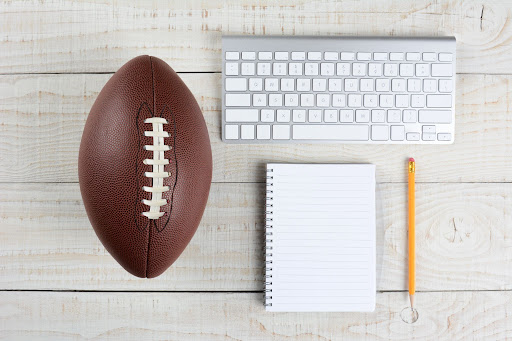 football next to keyboard notepad and pencil