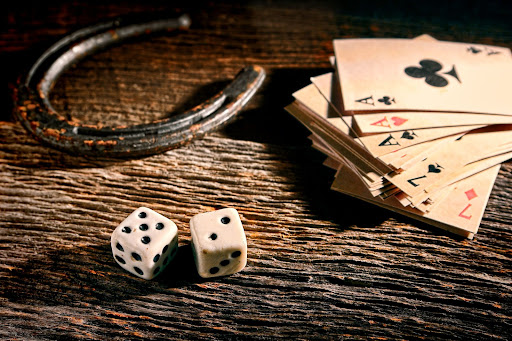 playing cards dice and horseshoe on wooden surface