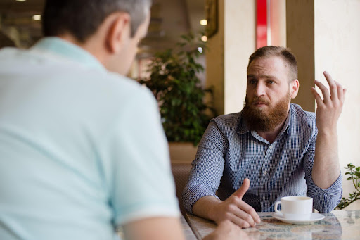 man talking to other man in coffee shop