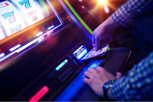hand inserting bill into slot machine